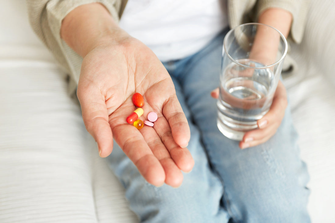 Hand holding different dietary supplements